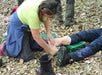 Person applying a bandage to another person's foot in a forest setting